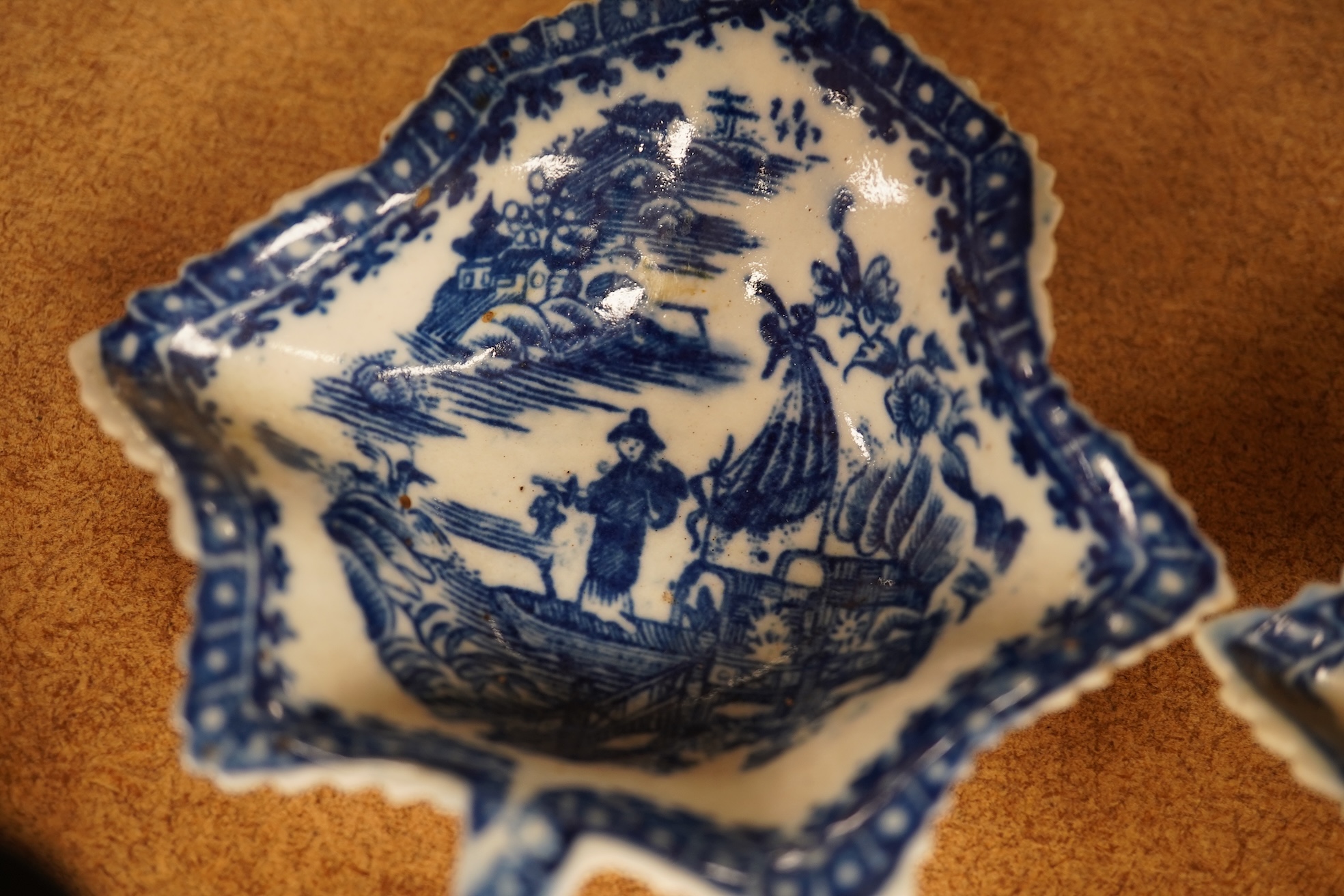 Two late 18th century Worcester or Caughley Cormorant fisherman pattern leaf pickle dishes and two early 19th century blue and white pottery leaf pickle dishes, largest 14.5cm long.